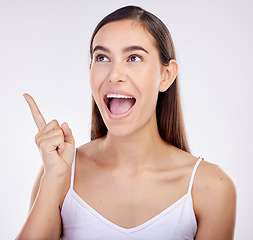 Image showing Pointing, surprise and woman excited, announcement and happiness on a white studio background. Wow face, person or model with shock, hand sign and choice with ideas, promotion and news with promotion