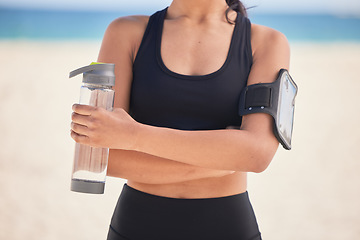 Image showing Woman, fitness and water with arms crossed on beach for workout, exercise or natural outdoor nutrition. Hands of female person with bottle of mineral liquid for running, training or healthy wellness