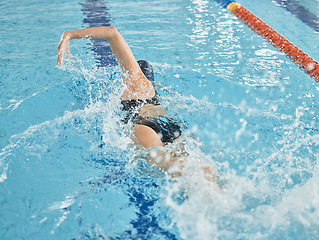 Image showing Fitness, sports and a swimming woman for training, competition or exercise in a pool. Stroke, active splash and a professional swimmer, athlete or girl in the water for cardio workout or a race