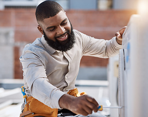 Image showing Building, engineer and air conditioner install with a black man on a roof for construction or manual labor. Industrial, engineering and an electrician working on ac repair for maintenance or service