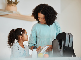 Image showing Mother packing lunch for her girl child for health, wellness snacks in the kitchen of their home. Happy, bonding and young mom talking and preparing food for her kid for school in their family house.