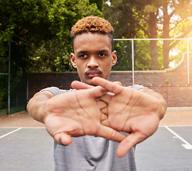 Image showing Sports, basketball and man stretching on court for competition, training or fitness games. Face of serious male athlete, player and warm up arms for workout, thinking of performance action or contest