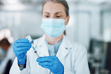 Image showing Woman doctor in mask, needle and covid vaccine bottle for hospital laboratory research. Healthcare, medicine and medical professional with sample syringe for corona vaccination in pharmaceutical lab.