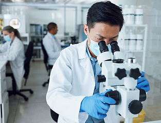 Image showing Microscope, science and asian man with mask in laboratory to review virus particles, medical test and biotechnology. Scientist, research and investigation of innovation, dna analysis and results