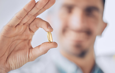 Image showing Man, hand of doctor and pill, pharmaceutical drugs and treatment of illness at hospital with blurred background. Healthcare, medicine and medical professional with gold capsule to help with health.