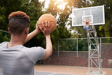 Image showing Man, basketball and net outdoor to score points, winning and aim for target from the back. Player, court and athlete prepare to throw ball in hoop for fitness, sports games and competition training