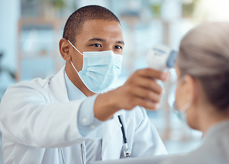 Image showing Doctor in face mask, patient and thermometer in office for covid test, safety and healthcare in hospital consultation. Temperature check, corona and woman at clinic with medical professional for exam