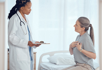 Image showing Healthcare, consultation and doctor with senior patient in discussion on chest pain problem. Professional, clipboard and female medical worker talking to elderly woman with heart sickness in hospital