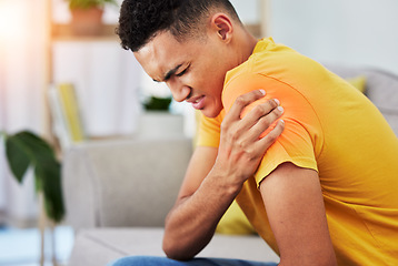 Image showing Man, sofa and shoulder pain in home, massage and relief, stress or injury in living room. Health, wellness and self care, person on couch with muscle problem, fatigue or physical therapy in apartment