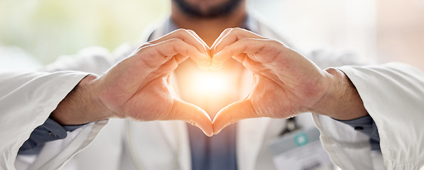 Image showing Medical, light and doctor heart hands for love, support and healthcare in a hospital or clinic by medicine professional. Trust, hope and worker with bright sign, symbol or gesture for cardiology