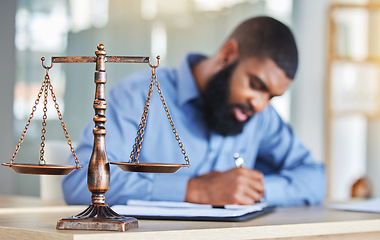Image showing Scale, notes and black man in office, lawyer or judge at desk with paperwork, research or crime report. Justice, icon and attorney at law firm writing in notebook, legal administration and contract.