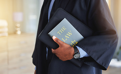 Image showing Law, book and hands of a judge with knowledge on the rules or research of legal constitution, regulation or policy from government. Black man, lawyer or expert attorney of court justice and judgment