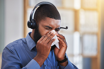 Image showing Sick, black man and blowing nose in call center office for flu, allergies, and health risk in telemarketing agency. Face of salesman, CRM agent and tissue for virus, bacteria and sneeze for allergy