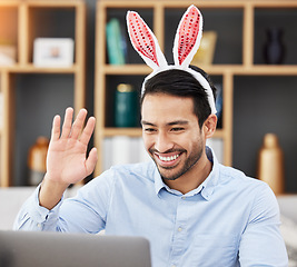 Image showing Business man, bunny ears and laptop with video call, wave and smile for contact, networking and festive fashion. Entrepreneur, rabbit emoji and webinar with computer, hello and funny for Easter party