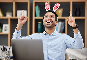 Image showing Bunny ears, easter and celebration by business man excited, happy and winning in an office with success. Winner, rabbit and employee or person with victory, achievement and using a laptop for profit