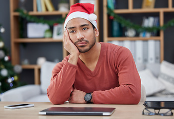 Image showing Bored, christmas hat and exhausted man in the office while working on a creative project. Tired, burnout and young professional male designer with xmas decorations working in the modern workplace.