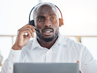 Image showing Black man thinking while consulting on laptop in call center for customer service, advisory and questions. Face of serious salesman working in CRM agency for telecom solution, tech support and help