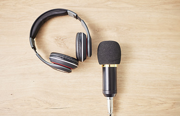 Image showing Above, microphone and headphones on a table for a podcast, radio or broadcast. Music, desk or musical gear, equipment or a mic for live streaming, musician recording or technology in an office