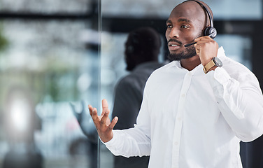 Image showing Black man, microphone and consulting in call center for customer service, advisory help and FAQ questions. Serious salesman working in CRM agency for telecom solution, tech support and communication