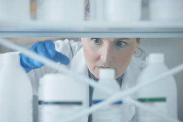 Image showing Scientist woman, shelf and bottle in lab with choice, thinking or idea for experiment, innovation or pharma career. Science lady, medical expert and pharmaceutical employee in laboratory for decision