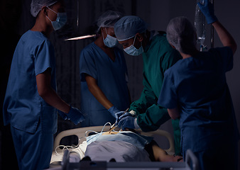 Image showing Hospital surgery, teamwork and surgeon operation, emergency service or helping patient in healthcare dark room. Clinic support, operating theatre or doctors doing medical procedure on client at night