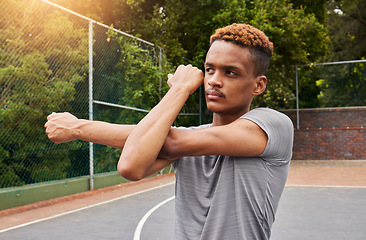 Image showing Man, basketball and stretching arms for sports flexibility, action and mobility. Workout, fitness and strong player with focus on court to prepare for training, exercise and thinking of competition