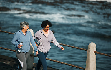 Image showing Fitness, exercise and senior women by ocean for healthy body, wellness and cardio on promenade. Sports, friends and female people with water bottle on boardwalk for walking, training and workout