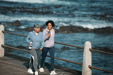 Image showing Fitness, walking and woman and senior mother by ocean for healthy body, wellness and cardio on promenade. Sports, happy and female people on boardwalk for exercise, marathon training and workout