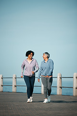 Image showing Exercise, walking and senior women by ocean for healthy body, wellness and cardio on promenade. Sports, friends and happy female people in conversation on boardwalk for fitness, training and workout