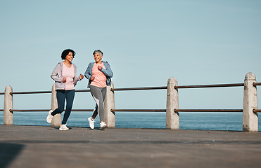 Image showing Senior women, fitness and running at beach for health, wellness and exercise in nature together. Elderly, friends and ladies at sea talking, workout and active retirement, fun and bonding ocean run