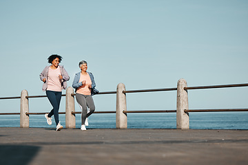 Image showing Senior, fitness and women friends at the beach for running, bond and morning cardio in nature together. Ocean, workout and elderly female runners happy, talking and enjoy fresh air, run and training