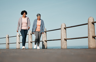 Image showing Fitness, walking and senior women by ocean for healthy lifestyle, wellness and cardio on promenade. Sports, friends and female people in conversation on boardwalk for exercise, training and workout