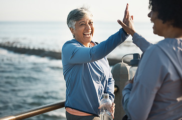 Image showing High five, fitness and senior women friends at beach with exercise, celebration and excited in nature. Sport, people and elderly females with hands in support of wellness, training or success at sea