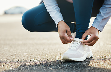 Image showing Sports, closeup and woman tie shoes outdoor in the road for running workout in the city. Fitness, health and zoom of female athlete tying her laces for cardio exercise for race or marathon training.