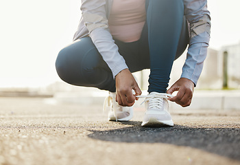 Image showing Fitness, runner and woman tie shoes outdoor in the road for running workout in the city. Sports, health and closeup of female athlete tying her laces for cardio exercise for race or marathon training