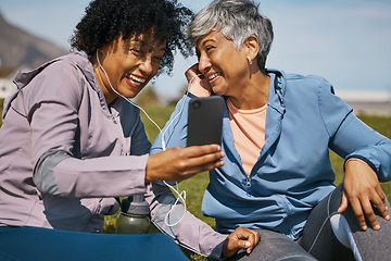 Image showing Phone, fitness and music with senior friends on the grass outdoor taking a break from their workout routine. Exercise, smile and elderly people streaming audio while laughing on a field for wellness