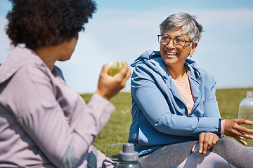 Image showing Talking, exercise and senior women friends on the grass outdoor taking a break from their workout routine. Fitness, training and healthy eating with elderly people chatting on a field for wellness