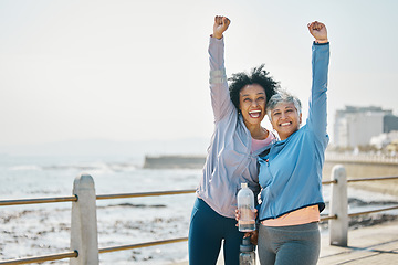 Image showing Success, women and friends, fist pump and fitness goals with running outdoor, winning and health. Happy senior female people, exercise achievement while training for marathon with cheers at beach