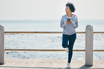 Image showing Relax, phone and fitness with black woman at beach for running, workout and tracking app. Network, communication and contact with female runner training in nature for technology, sports and mobile