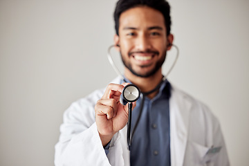 Image showing Healthcare, portrait and man doctor hand holding stethoscope in studio for hospital, checkup or exam. Face, smile and male cardiovascular expert with medical tool for chest, lungs and heartbeat check