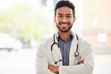 Image showing Portrait, smile and asian man doctor with arms crossed in hospital with stethoscope for consulting on blurred background. Happy, face and male healthcare expert proud of clinic, service or help