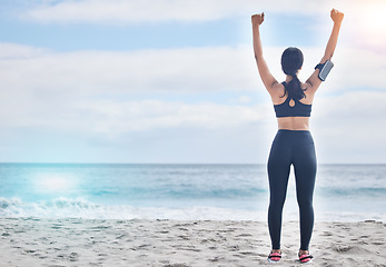 Image showing Fitness, celebration and woman with arms up at beach, mockup and winning achievement in nature. Ocean, goals and exercise girl for workout motivation, victory and blue sky with waves in natural space