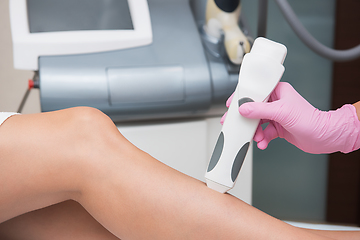 Image showing Specialist makes skin tone measurements on a womans leg