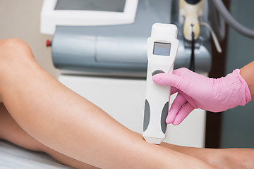 Image showing Specialist makes skin tone measurements on a womans leg