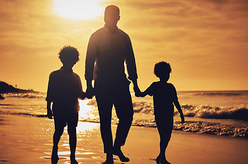 Image showing Silhouette, sunset and father holding hands with children at the beach for walking, bonding and vacation. Dark, care and dad with kids at the ocean for a walk, travel and quality time together