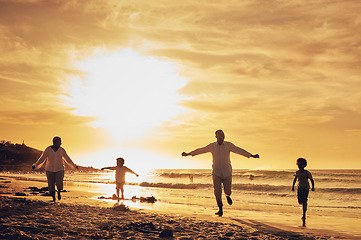 Image showing Family, freedom with silhouette on beach at sunset, parents and kids running together with travel, care free and happy outdoor. Man, woman and children, ocean waves and vacation, nature and happiness