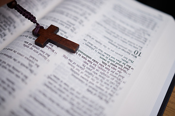 Image showing Background, christian and rosary on bible book for praying, spiritual faith or holy worship to God in heaven. Closeup of cross for studying religion, reading prayer or scripture story of Jesus Christ