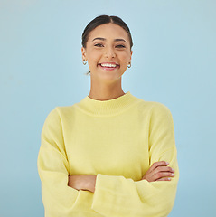 Image showing Smile, portrait and woman in studio with arms crossed, fashion and youth mindset on blue background. Confidence, pride and happy face of girl with beauty, gen z style and excited positive attitude.