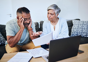 Image showing Frustrated senior couple, documents and laptop in debt, financial crisis or struggle on sofa at home. Upset elderly man and woman in disagreement, argument or fight with finance, bills or expenses