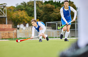 Image showing Fitness, workout and female hockey players training for a game, match or tournament on an outdoor field. Sports, exercise and young women playing at practice with a stick and ball on pitch at stadium